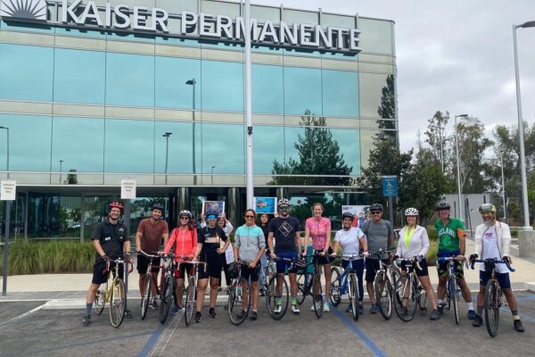 Riders pose in front of the Kaiser Permanente Medical Centre